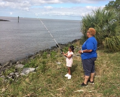 Adult and Child Fishing from grassy area - Photo by Cypremort Point State Park