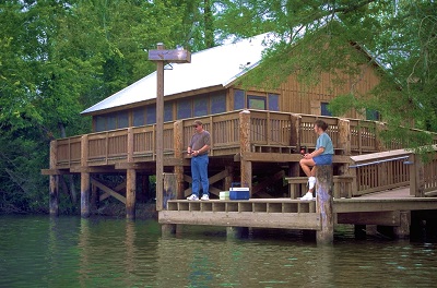 Couple fishing from dock in front of wooden cabin at Lake Fausse Pointe State Park - Courtesy Louisiana State Parks