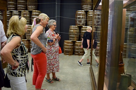 Three women look at barrel exhibit at the Tabasco Factory Tour on Avery Island