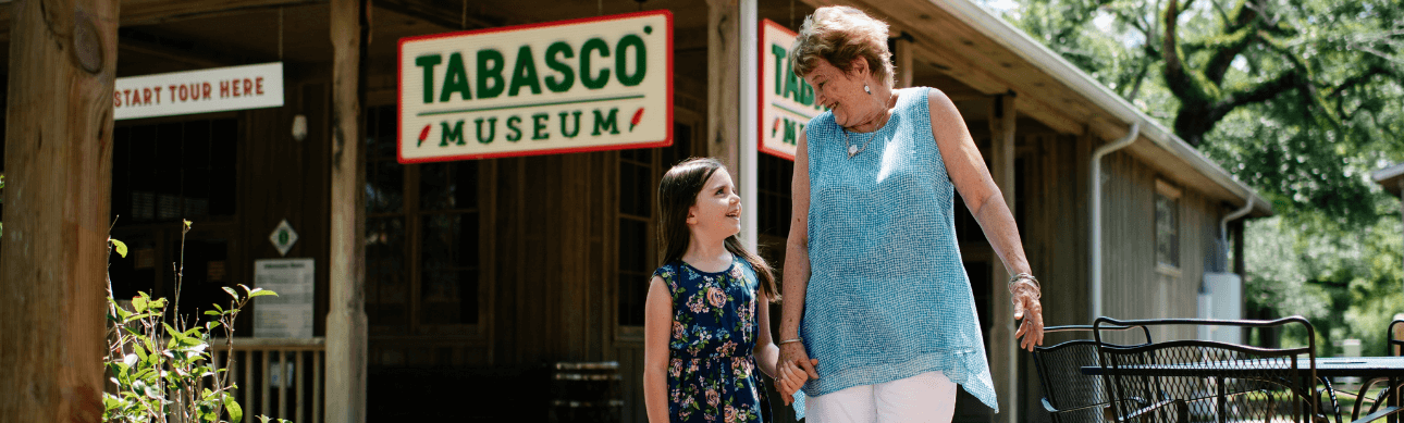 Grandmother and granddaughter hand in hand in front of the Tabasco Museum in New Iberia, Louisiana.